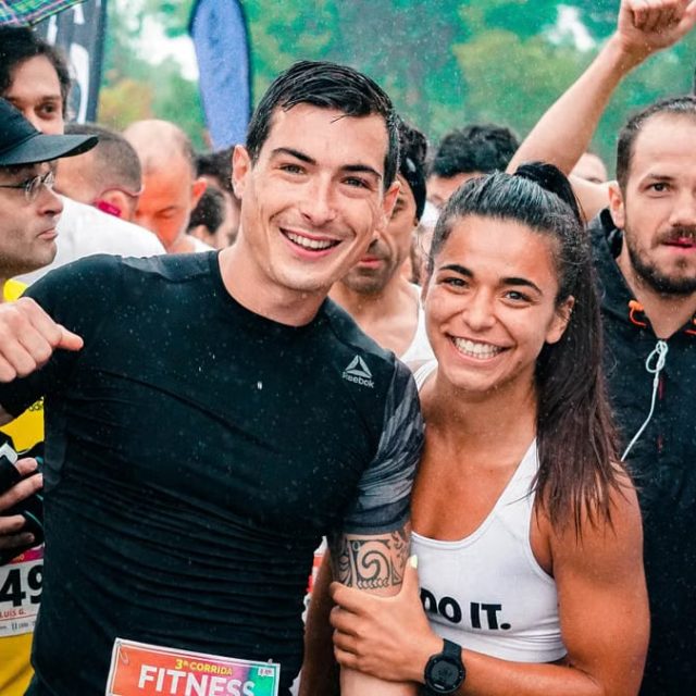 Group of runners smiling in the rain during a marathon race event.